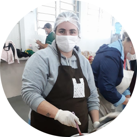 Foto de uma voluntária durante a montagem das pizzas.