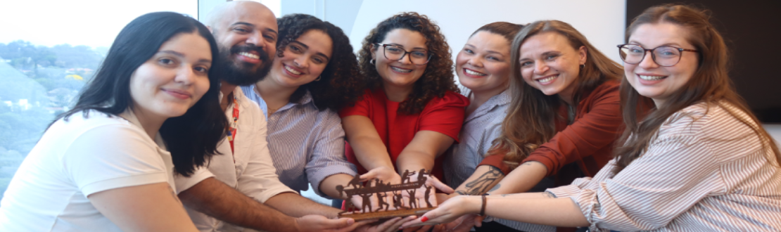 Foto da equipe do Instituto BRF, um grupo de sete pessoas, com os braços estendidos e no centro o troféu.