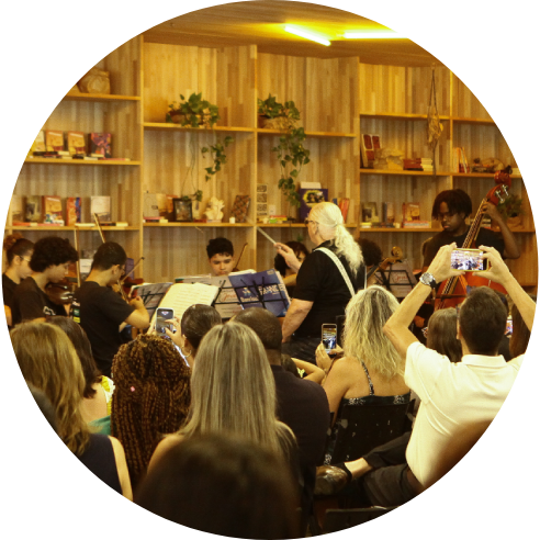 Foto da Orquestra Pão dos pobres em apresentação no auditório.