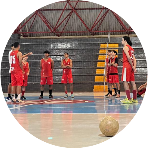 Foto de um grupo de meninos uniformizados em uma quadra coberta.