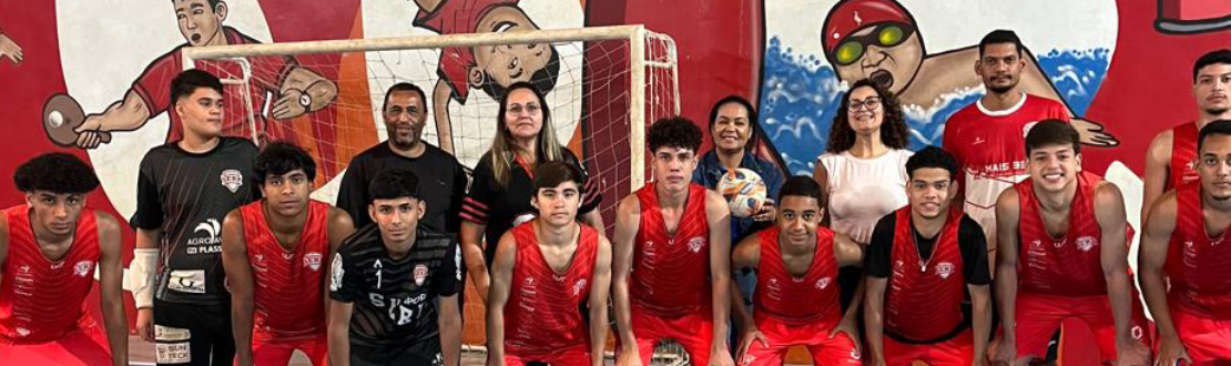 Foto de um grupo de meninos e representantes do Instituto MBRF e da SERP posicionados em uma quadra. Alguns estão abaixados e com as mãos nos joelhos, enquanto o restante do grupo está em pé.