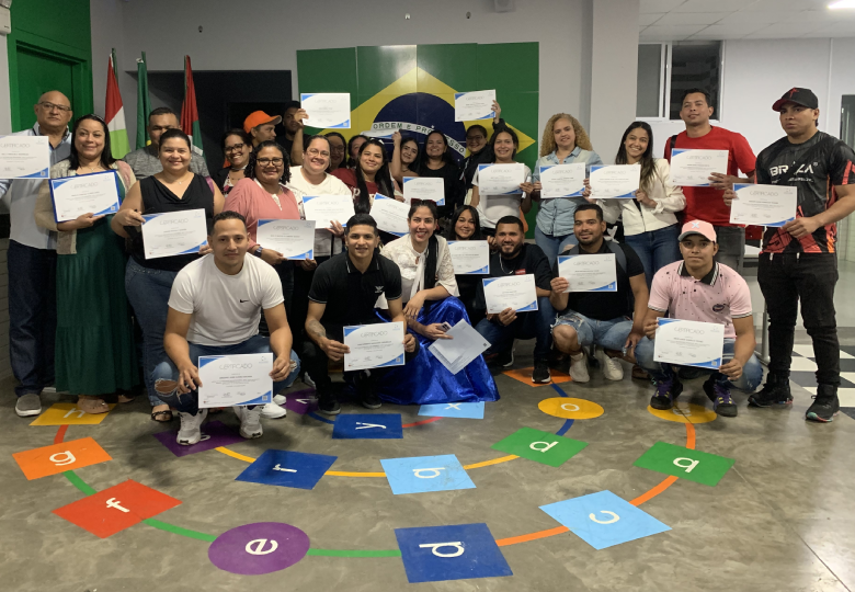 Foto de um grupo de pessoas segurando certificados de conclusão do curso.