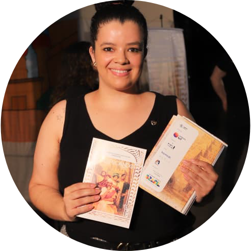 Foto de uma mulher segurando folders da peça.