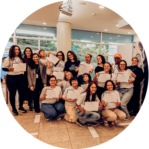 Foto de um grupo diverso de mulheres posando sorridentes lado a lado segurando diplomas nas mãos.