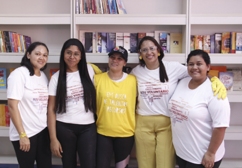 Foto de cinco voluntárias do Instituto BRF no interior da biblioteca.