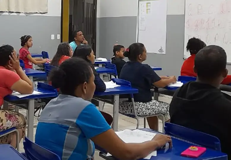 Foto de um grupo diverso de estudantes sentados em uma sala de aula.