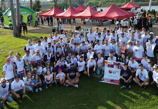 Foto das pessoas voluntárias do Instituto BRF que participaram da ação. Parte delas está em pé e outras sentadas na grama. Todos sorriem.